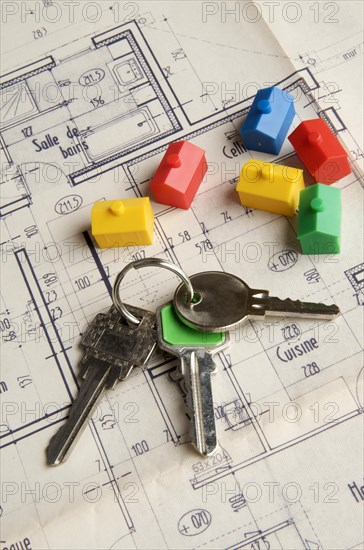House keys and miniature houses on a construction plan