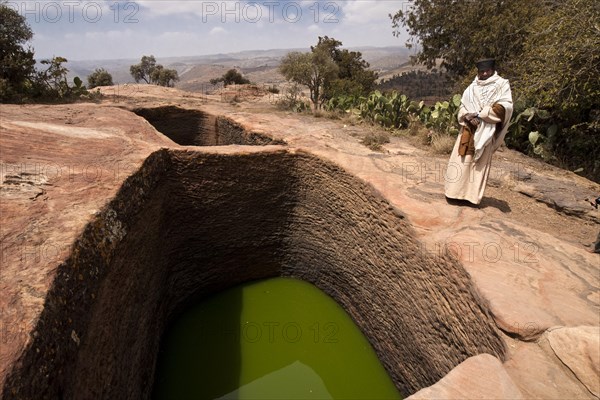 Orthodox monks at the holy water near the rock-hewn church of Mikael Imba