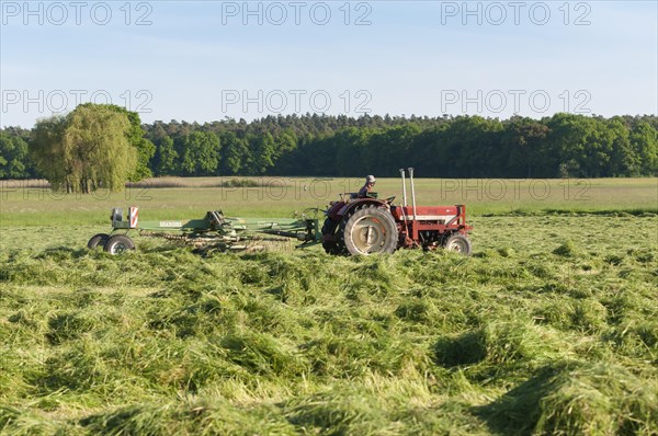 Tractor with hay turning machine