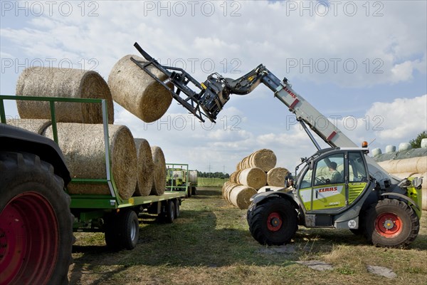 Bales of straw being loaded onto a trailer