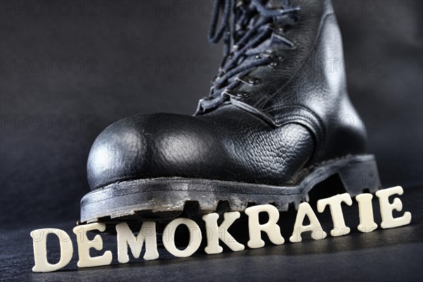 Combat boot standing on the word 'Demokratie'