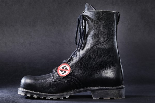 Combat boot with a badge with a crossed-out swastika