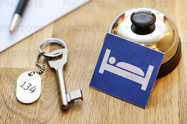 Bell and room key at a reception desk