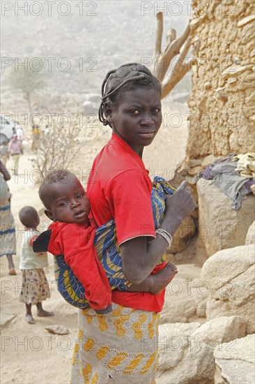 Woman of the Mafa ethnic group carrying a baby on her back