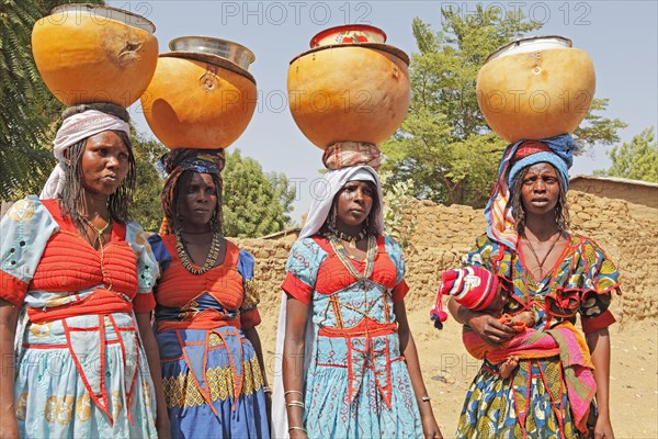 Fulani women carrying milk calabashes on their heads