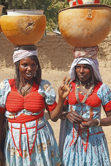 Fulani women carrying milk calabashes on their heads