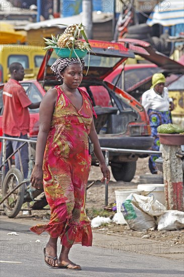 Market woman carrying pineapple on her head