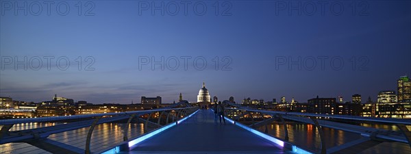 Millennium Bridge and London skyline at dusk
