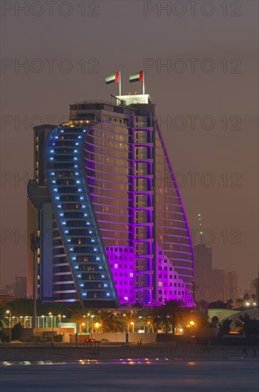 The illuminated Jumeirah Beach Hotel on Jumeirah beach at dusk