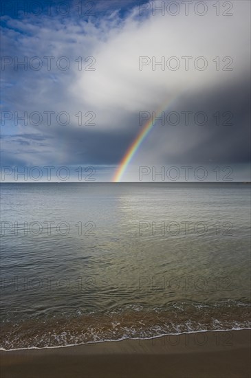 Sandy beach with rainbow over the sea