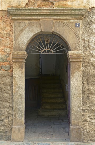 An open door and a decaying facade