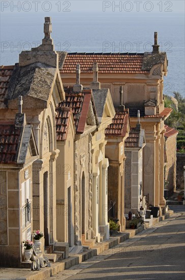 The typical above-ground tombs in the cemetery of Ajaccio with the water of the mediterranean sea in the background. Ajaccio is the capital of the mediterranean island of Corsica