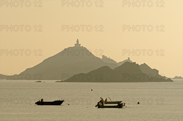 The silhouette of the islands Les Iles Sanguinaires with small boats in the foreground. Les Iles Sanguinaires are in the department Corse-du-Sud