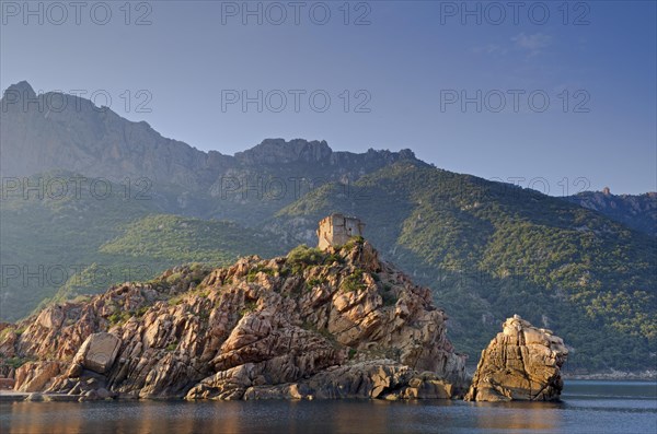 The Genoese Tower of Porto on top of a rocky hill and the Gulf of Porto