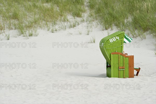 Green roofed wicker beach chair on the beach
