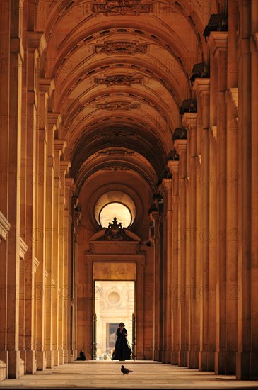 Woman setting up a tripod in an archway