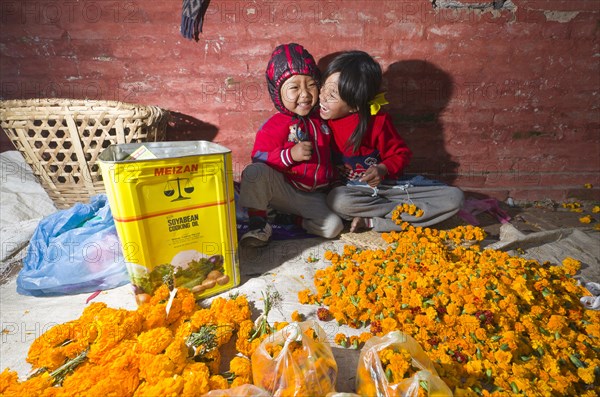 Two small children selling flowers