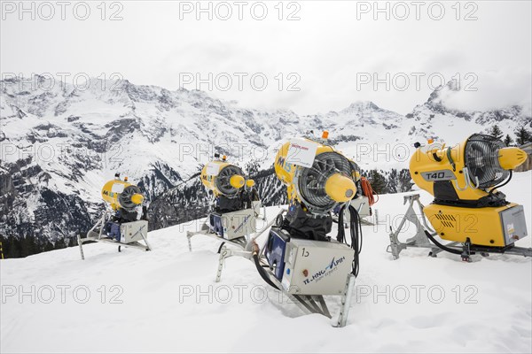 Snow cannon and snow-covered mountains