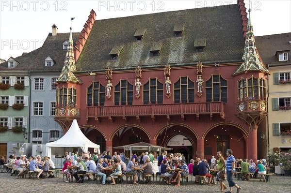 Wine stand and restaurants in front of the Historical Merchants Hall on Muensterplatz square or Cathedral Square