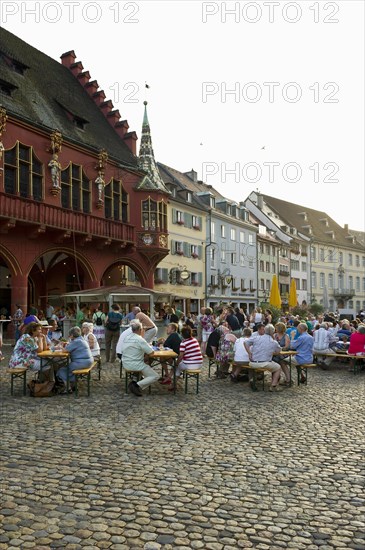 Wine stand and restaurants in front of the Historical Merchants Hall on Muensterplatz square or Cathedral Square