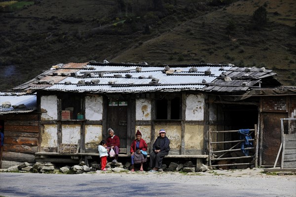 Small shop on the roadside with people sitting out the front