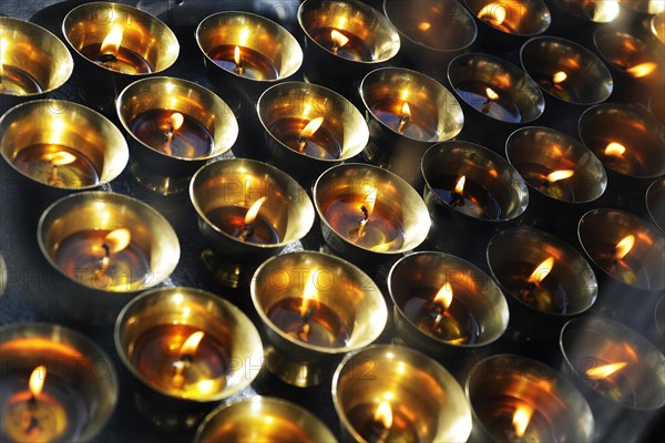 Yak butter lamps burning at a shrine en route to the monastery and temple complex of Taktshang-Lhakang