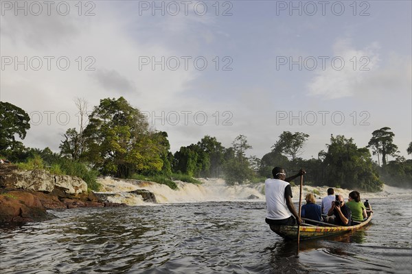 Boat in front of the cascades where the Lobe River plunges over 30 meters into the Atlantic