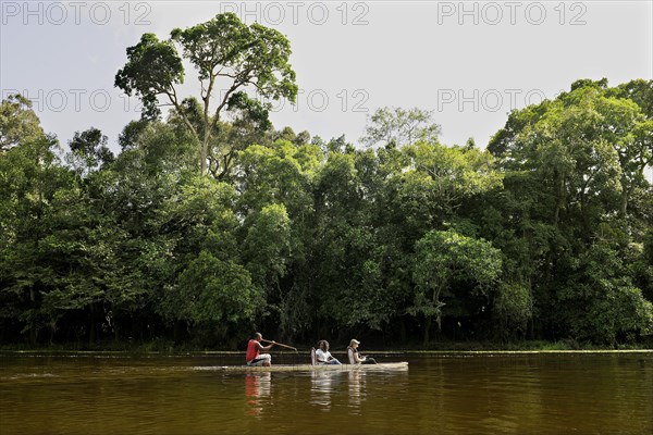 Tourists being rowed across the Nyong River