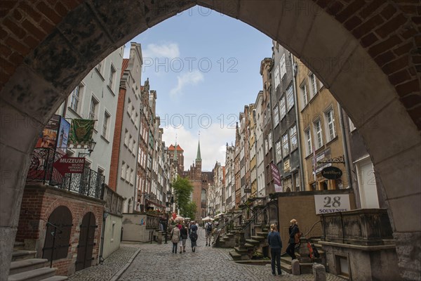 View through St. Mary's Gate or Brama Mariacka into Mariacka Street or Ulica Mariacka with the historic patrician houses and their porches or elevated terraces