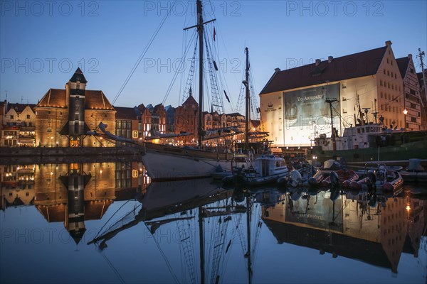 Crane Gate or Brama Zuraw in the historic row of houses at dusk