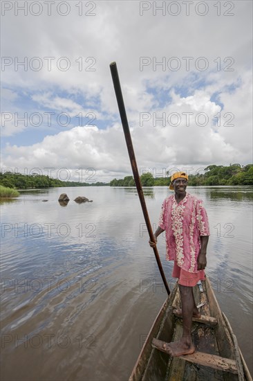 Man steering a pirogue on the Moa River at Tiwai Island Wildlife Sanctuary