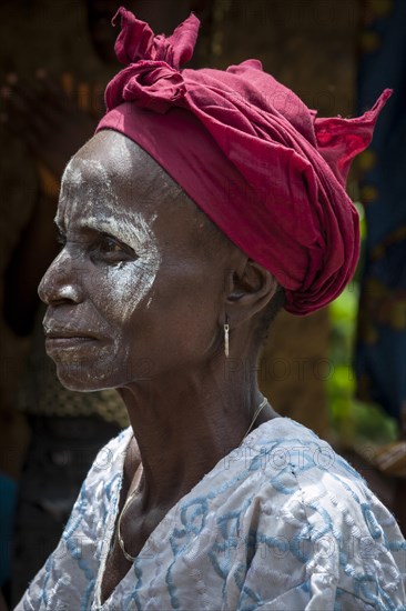 Woman with a headscarf and white paint on her face