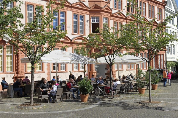 People sitting in front of the older part of the Gutenberg Museum