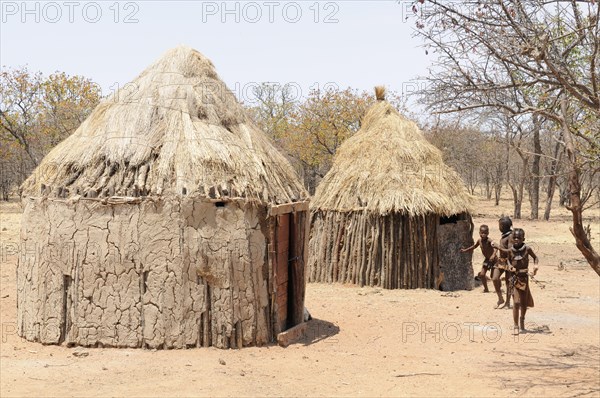 Himba children playing outside Himba huts in a Himba village