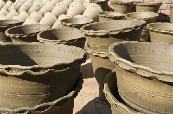Newly made pottery is drying in the sun before getting burned