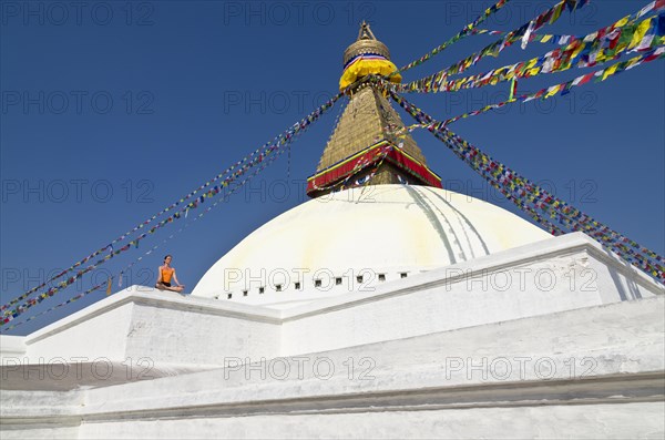 Young woman practicing yoga at the Boudnanath stupa