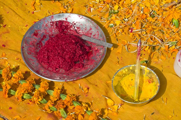 Colourpowder and coloured rice on yellow material to work with as a priest