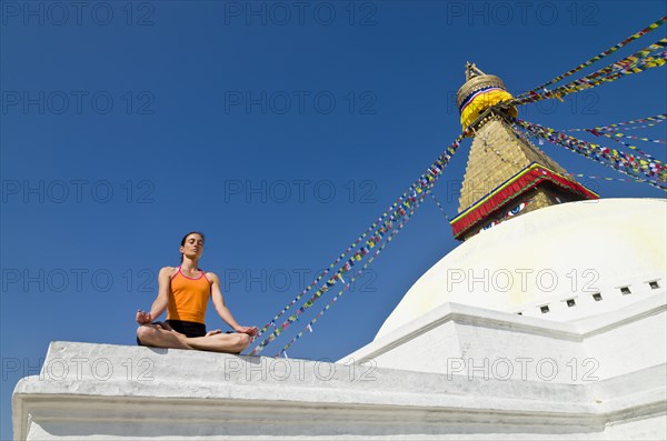 Young woman practicing yoga at the Boudhanath stupa