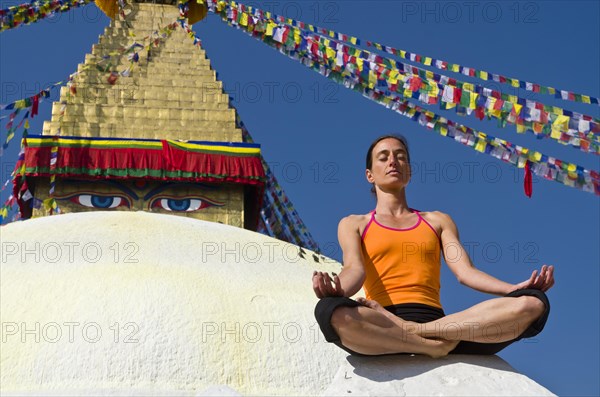 Young woman practicing yoga at Boudnanath stupa