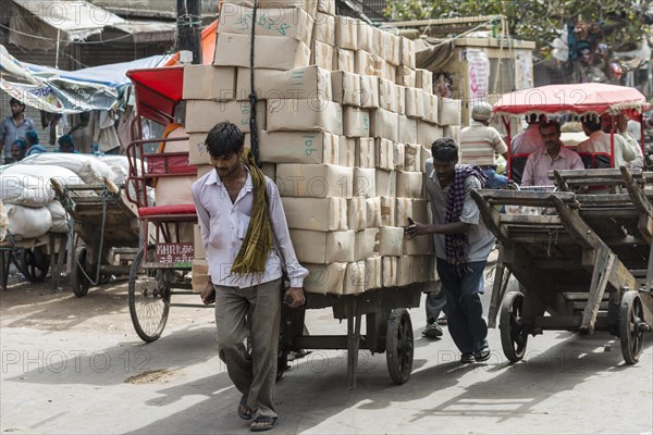 Men transporting goods on a hand cart on Khari Baoli Road