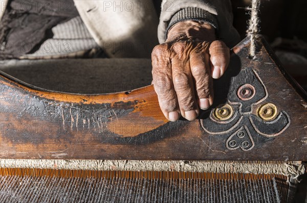 Old man weaving with a handloom