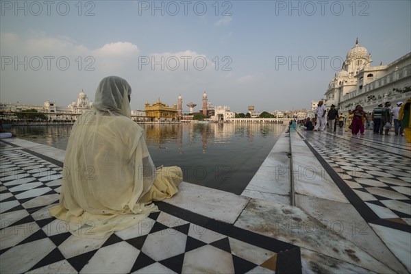 A Sikh devotee sitting at the holy pool