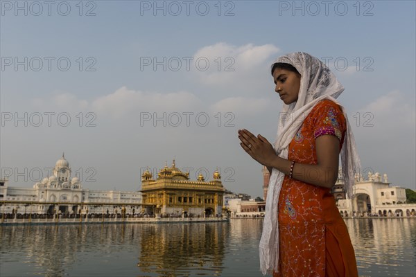 A Sikh devotee praying at the holy pool of the Harmandir Sahib or Golden Temple