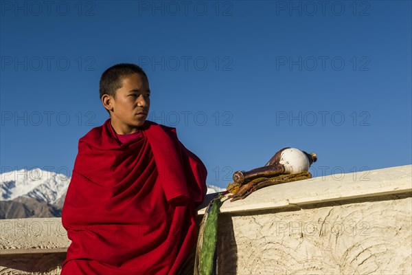 Monk on the roof of Thiksey Gompa monastery