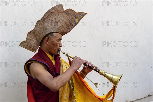 Monk making music as part of the opening ceremony of the Hemis Festival