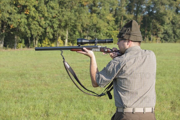 Hunter waiting for game with weapon at the ready