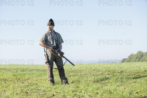 Hunter standing on a meadow