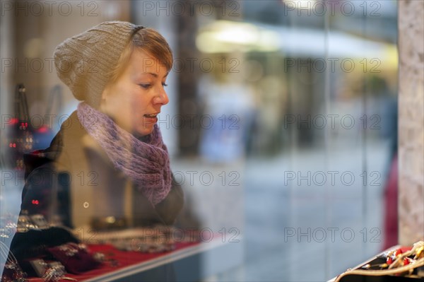 Young woman standing in front of the window of a jewellery store