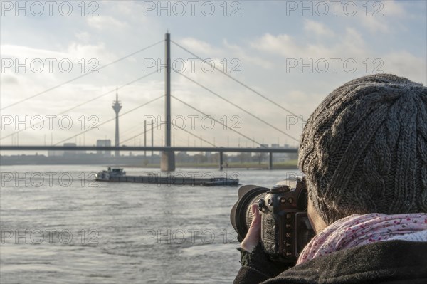 Young woman taking photographs of the Rhine