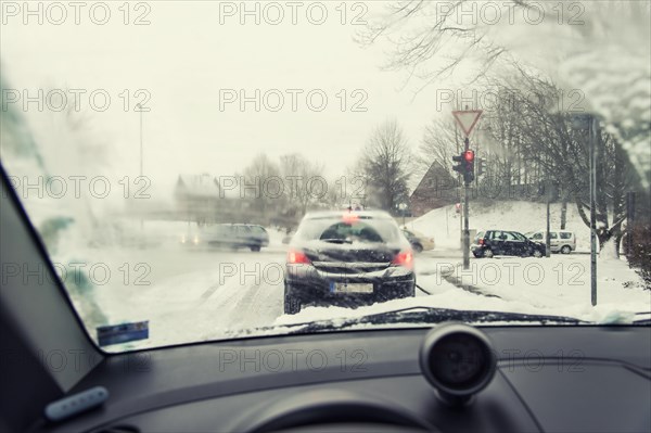 View through the windscreen of a car at red traffic lights at crossroads